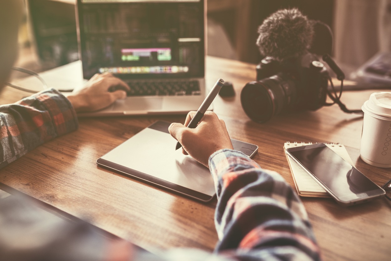 Youtuber editing video on laptop for up to worldwide through an online freelance work.