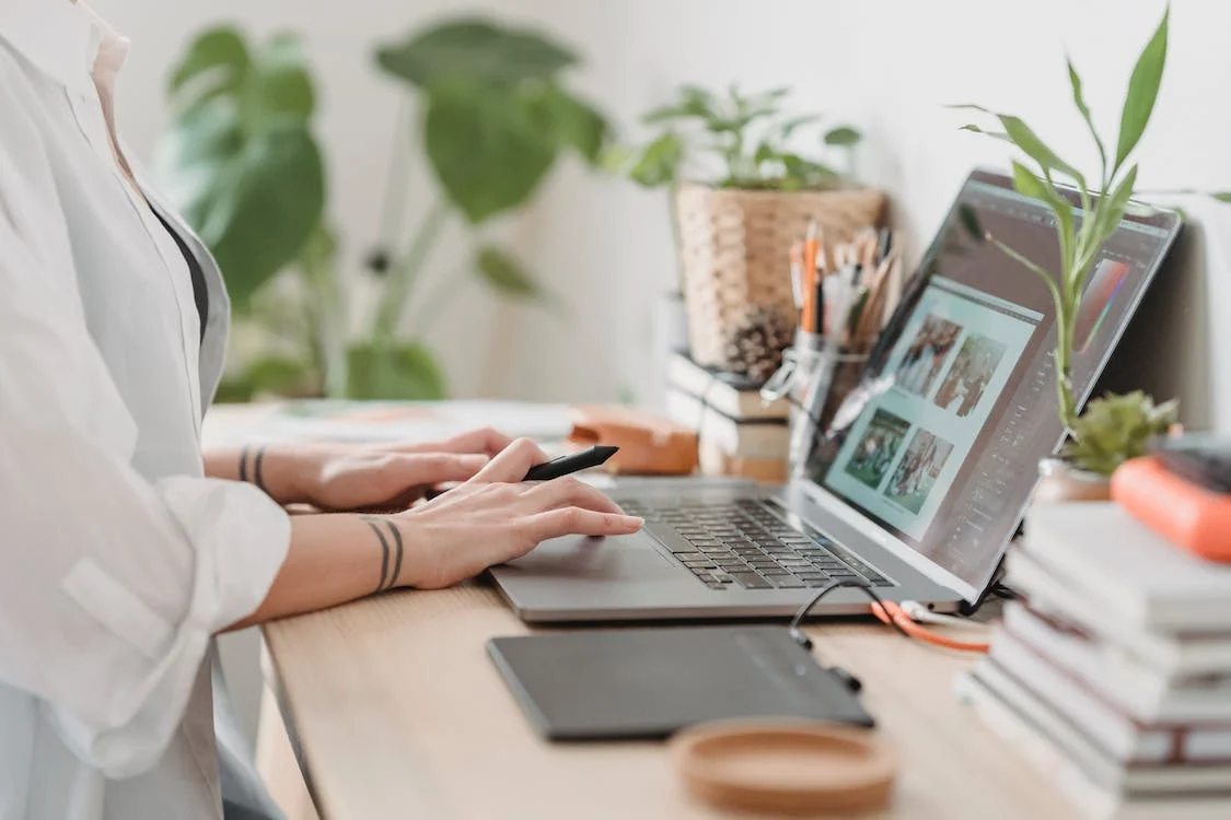 woman working retouching photo on a laptop at convenient workplace