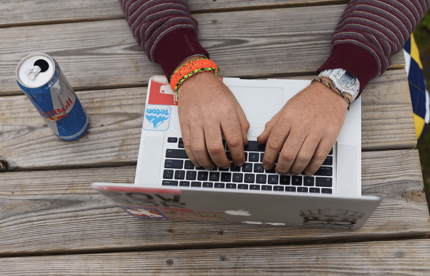 Hand typing on a laptop