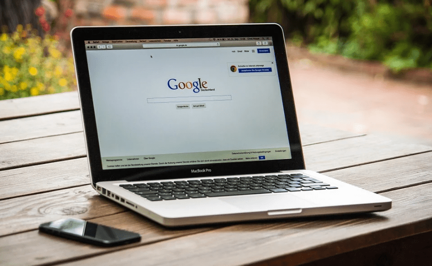 open laptop, Google search engine, phone, table, plants