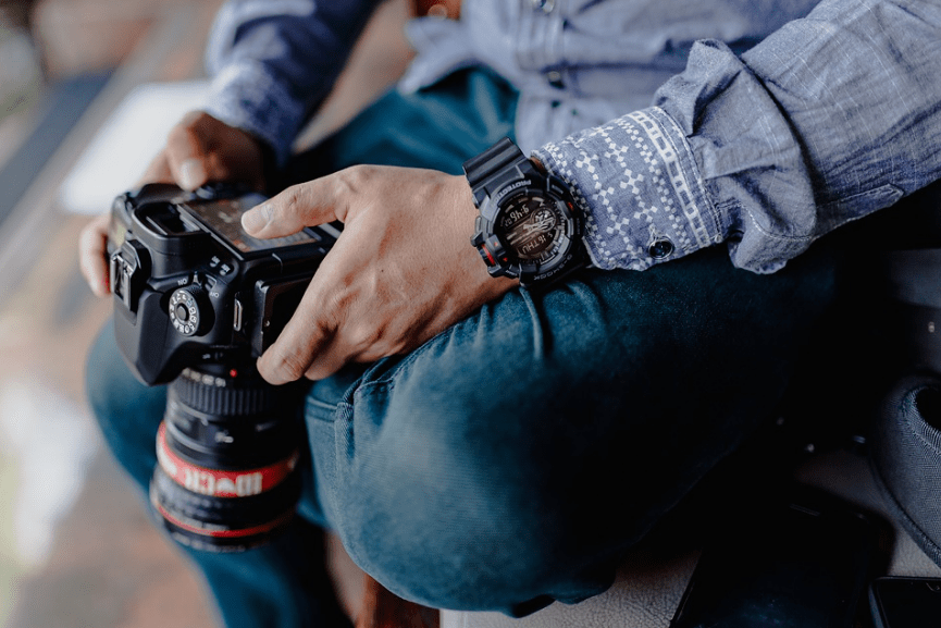 photographer holding a camera, camera, watch